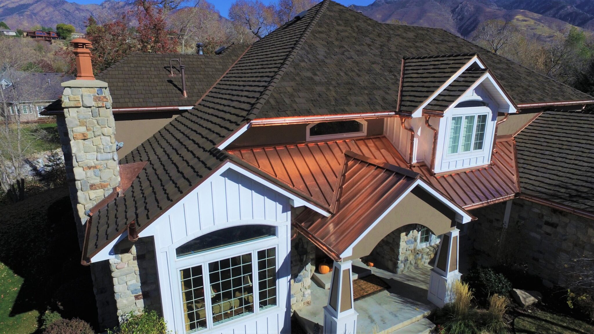 House with a tile roof and a copper metal accent roof over the front bay